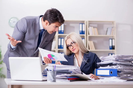 Clown boss rants over pie chart as stressed employee drowns in paperwork avalanche—office circus in full swing!