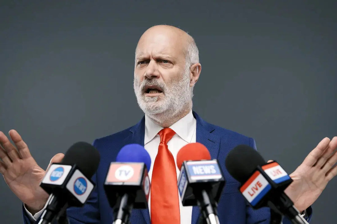 Corrupt clown politician shrugs at press mics in red tie—bald head, beard, and circus of excuses on full display!