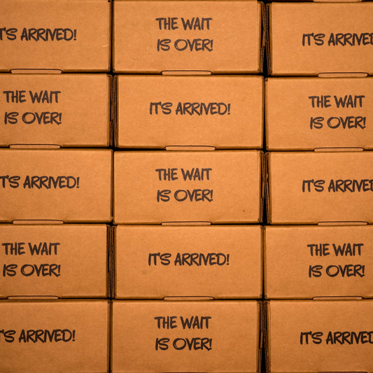 Stacked shipping boxes labeled "It's Arrived!" and "The Wait Is Over!" for Clown Nose in a Box, an anonymous prank gift
