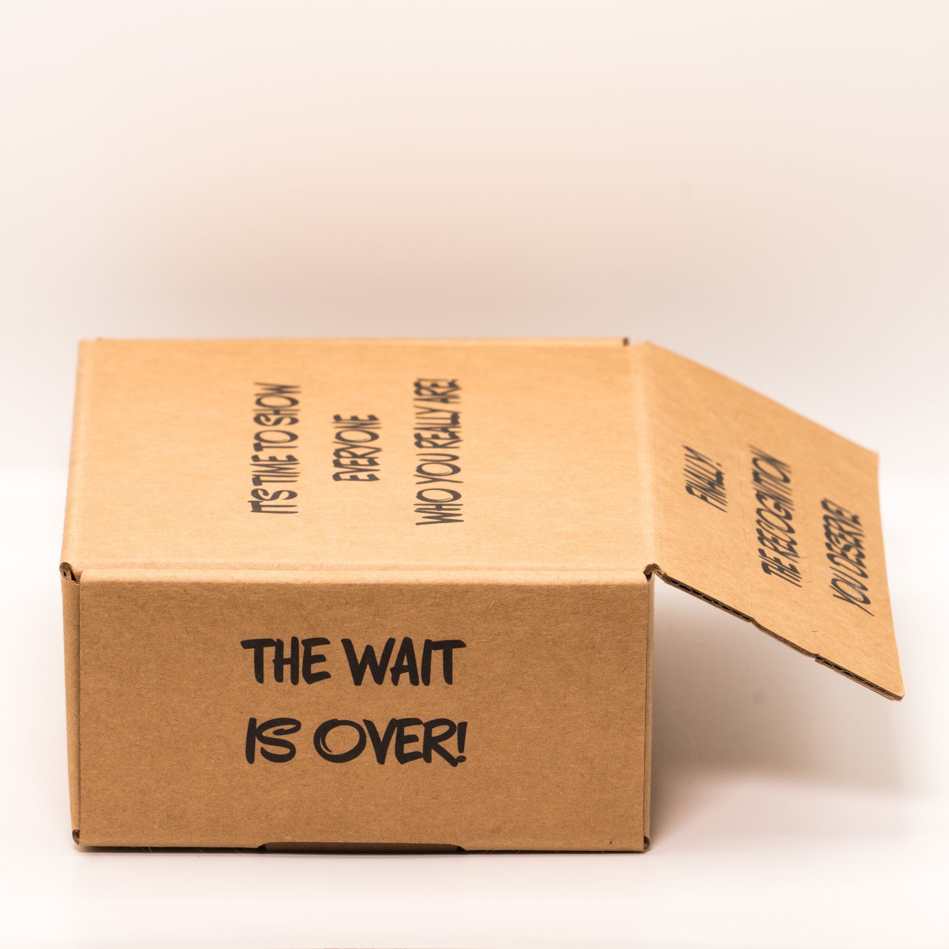 Open cardboard box with 'The Wait is Over!' text on left side on a white background.