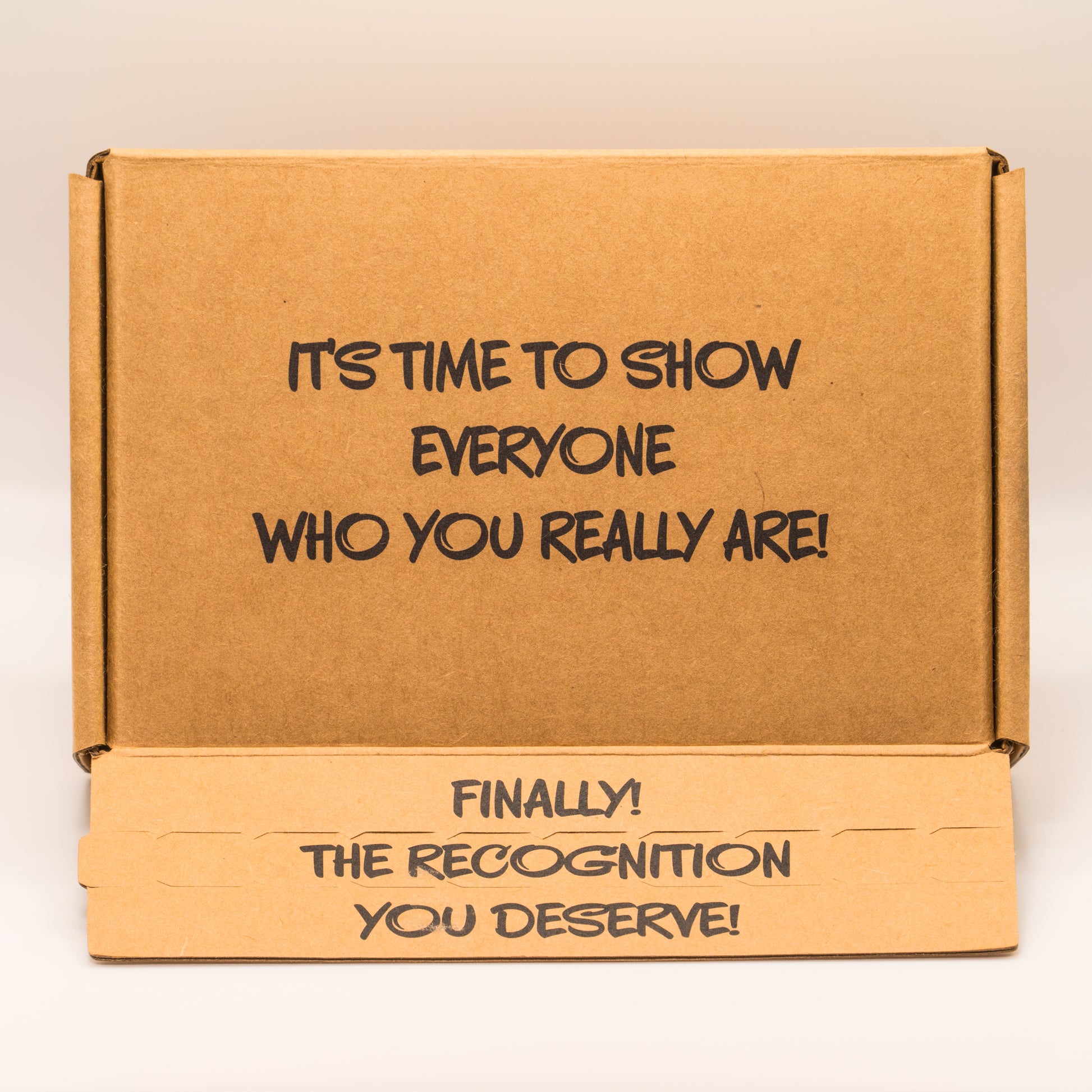Open cardboard box with 'It’s time to show everyone who you really are!' text on the top on a white background.